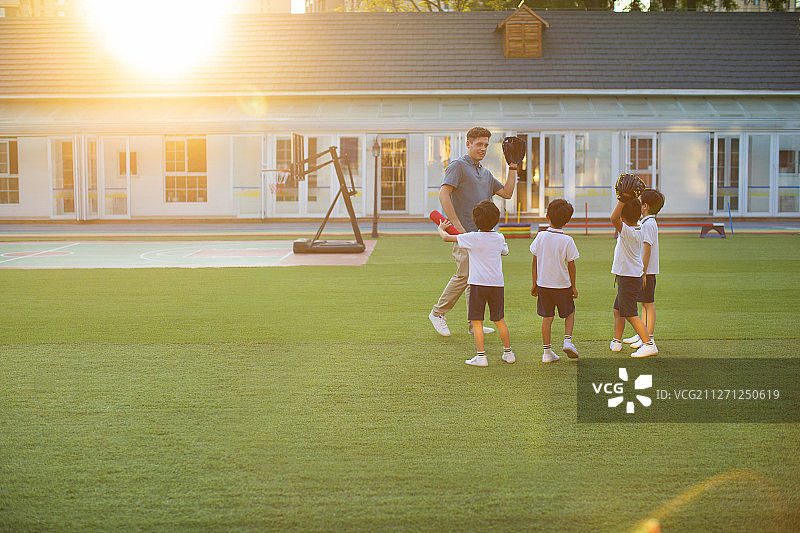 老师教孩子玩棒球图片素材