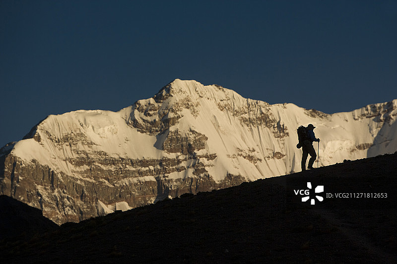 一位孤独的背包客在阿根廷门多萨的印加桥附近的山脊上徒步，背景是阿空加瓜山图片素材