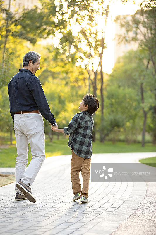 快乐的祖孙俩在公园一起散步图片素材