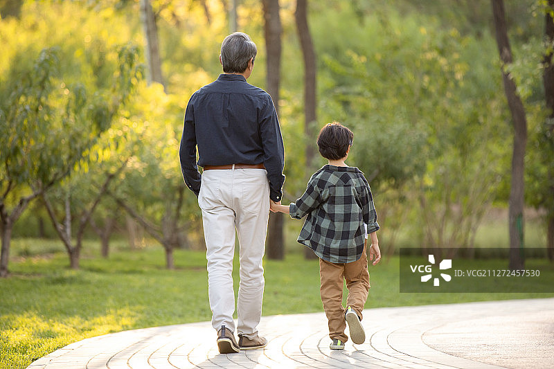 快乐的祖孙俩在公园一起散步图片素材