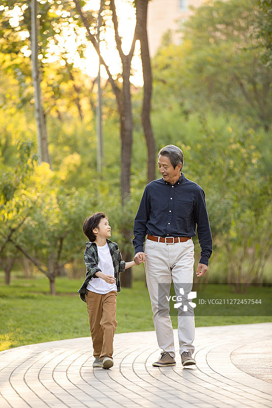 快乐的祖孙俩在公园一起散步图片素材