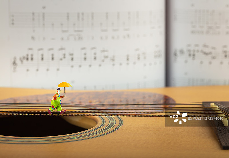 小丑在吉他琴弦上走钢丝图片素材