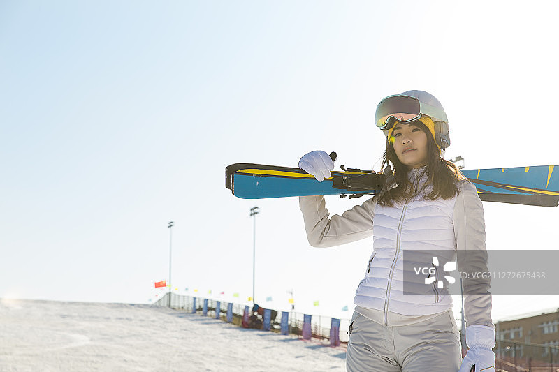 年轻女子在户外背着滑雪板去滑雪肖像图片素材