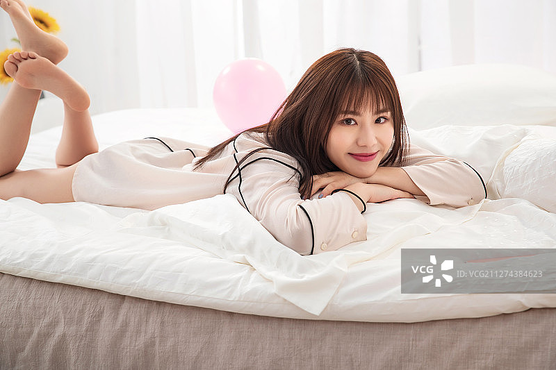 年轻女人趴在床上图片素材