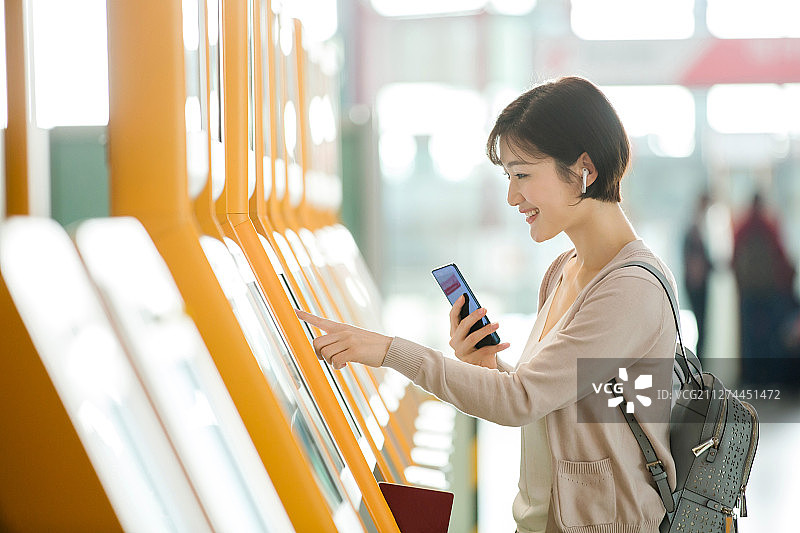 商务女士在机场使用自动售票机图片素材
