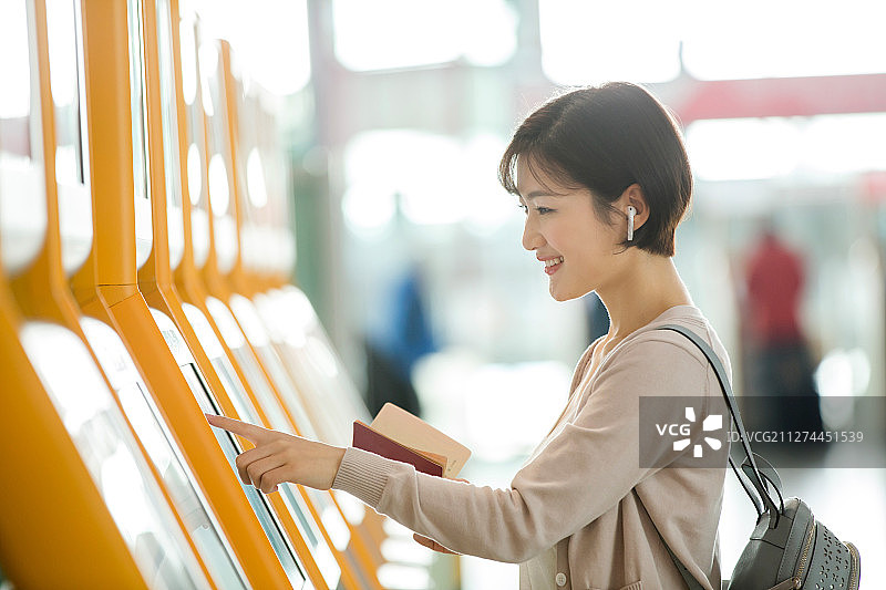 商务女士在机场使用自动售票机图片素材