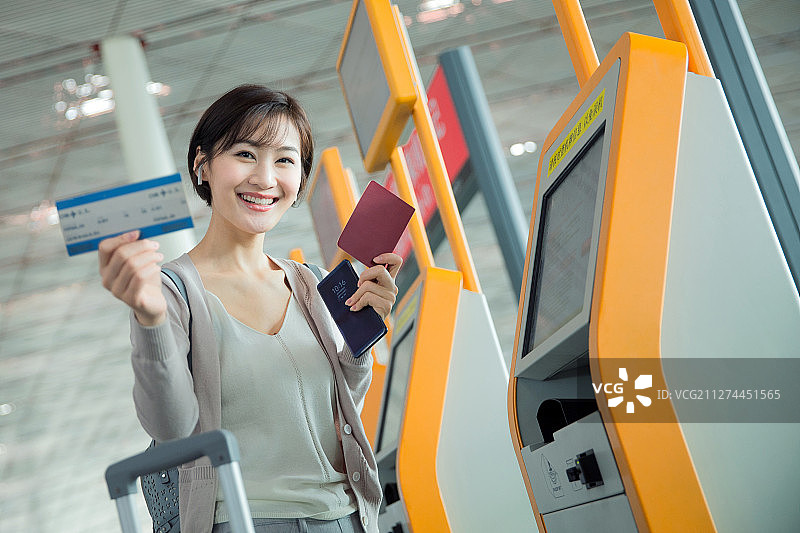 商务女士在机场使用自动售票机图片素材