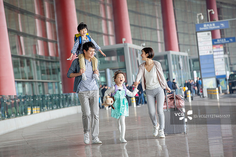 快乐家庭拿着行李在机场图片素材