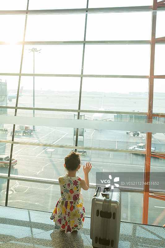 一个小女孩在机场候车厅往外看图片素材