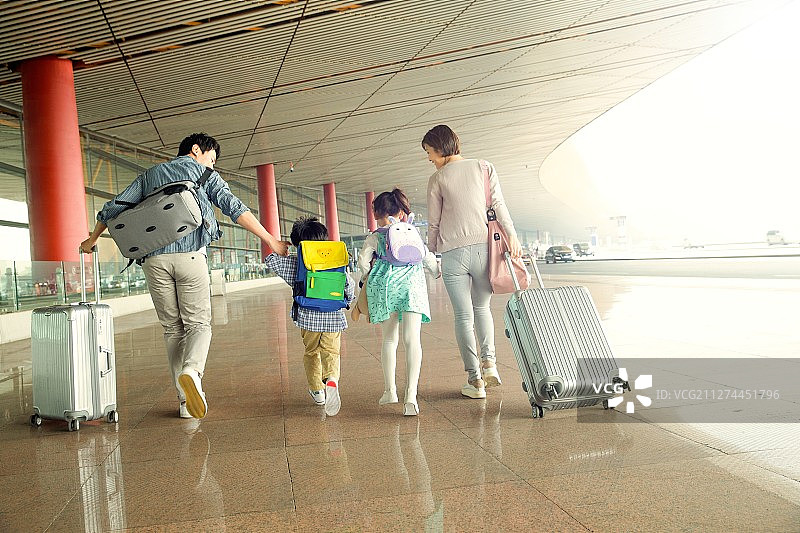快乐家庭拿着行李在机场图片素材