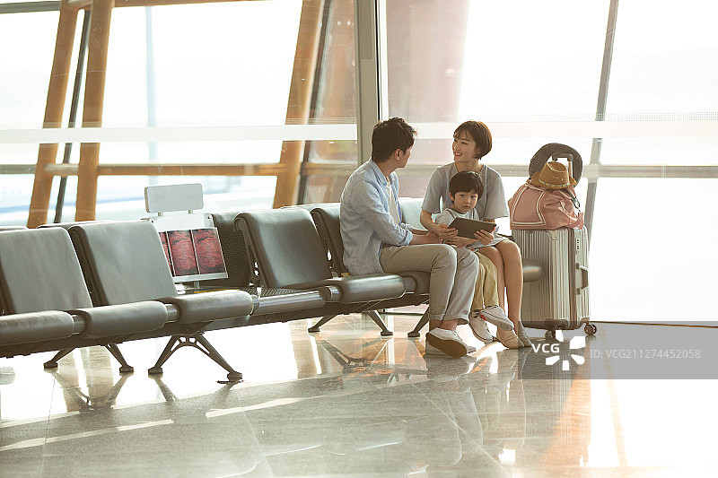 一家三口坐在机场候机大厅图片素材