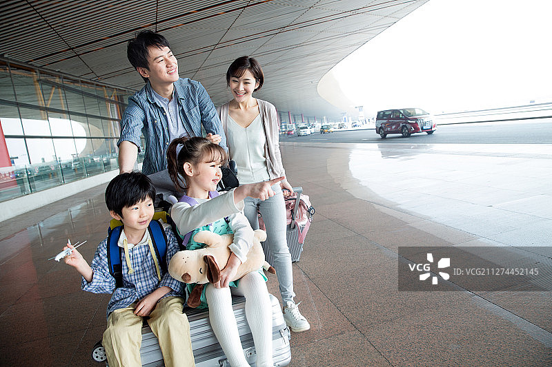 欢乐家庭在机场推着行李图片素材