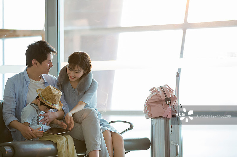 一家三口坐在机场候机大厅图片素材