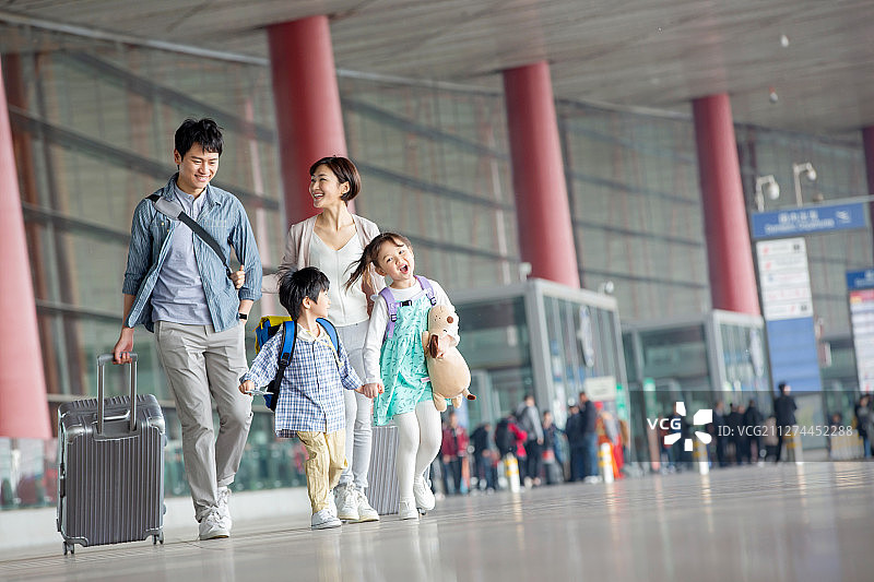快乐家庭拿着行李在机场图片素材