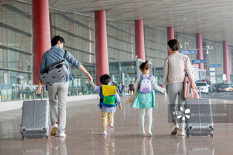 快乐家庭拿着行李在机场图片素材