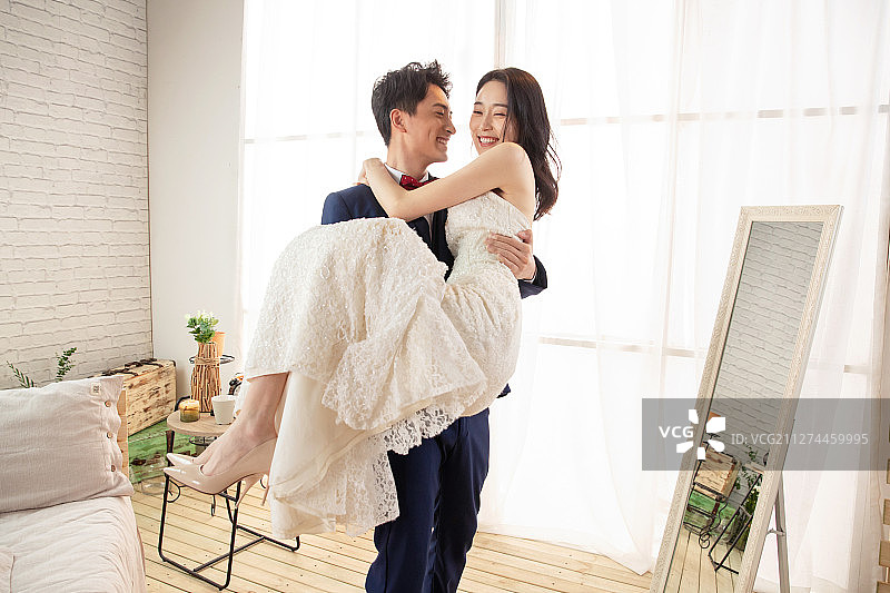 卧室里幸福的丈夫抱着妻子图片素材