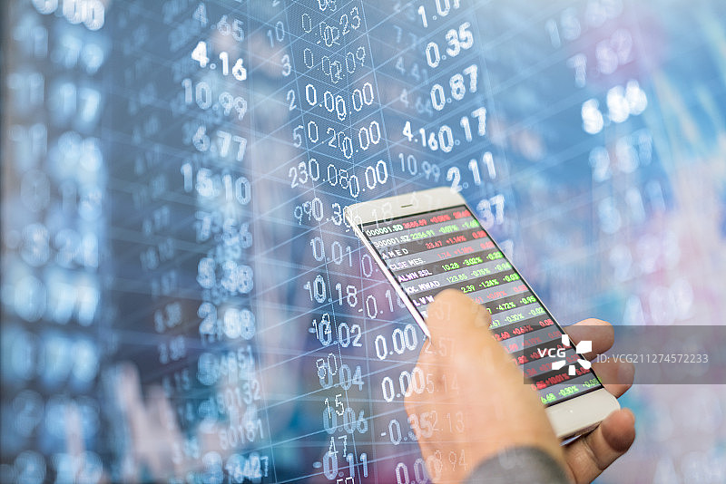 使用手机看股票的金融投资概念图片素材
