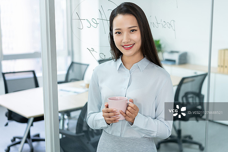 年轻商务女士在办公室喝咖啡图片素材