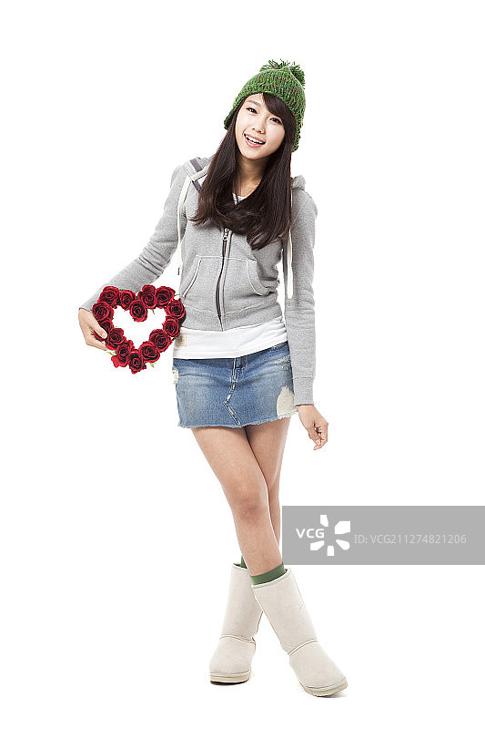 身穿冬装的女人手持心形花朵装饰摄影图片素材