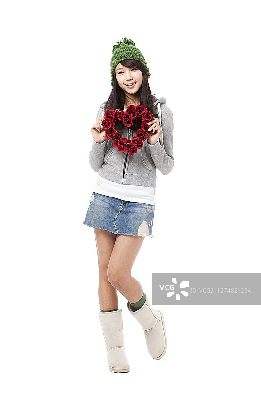 身穿冬装的女人手持心形花朵装饰摄影图片素材