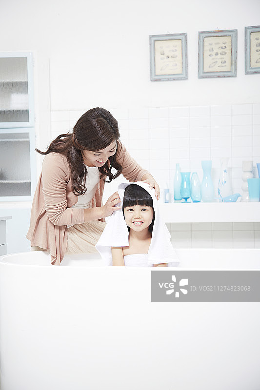 小女孩和她的母亲在浴室里梳妆打扮的摄影图片素材