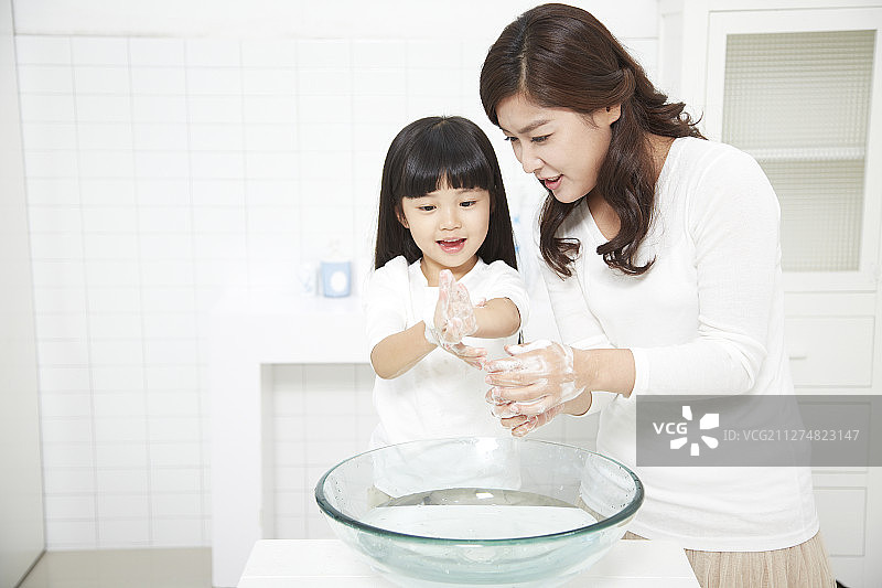 小女孩和她的母亲在浴室里洗手图片素材