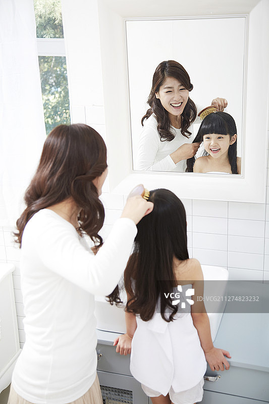 小女孩和妈妈在浴室里梳头的摄影图片素材