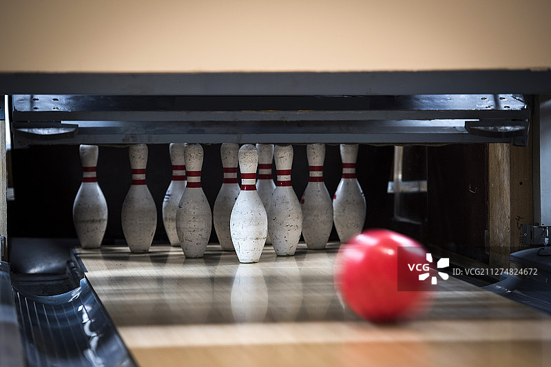 保龄球在球道上滚向球瓶的照片图片素材