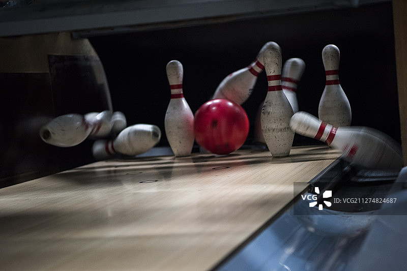保龄球在球道上滚向球瓶的照片图片素材