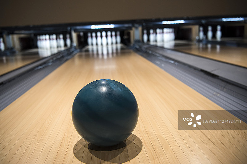 保龄球在球道上滚向球瓶的照片图片素材