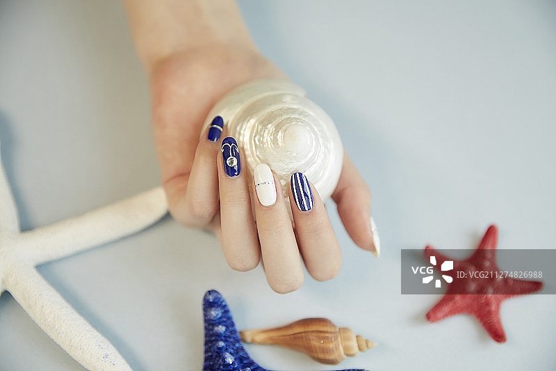 手部美甲的女人手持海星摆姿势摄影作品图片素材