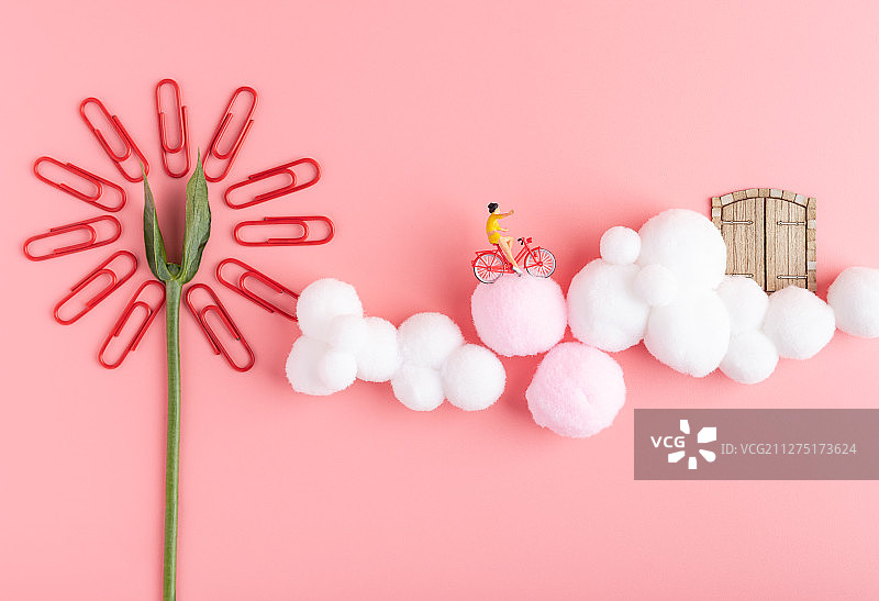 回形针花瓣粉色云朵上骑自行车的少女图片素材