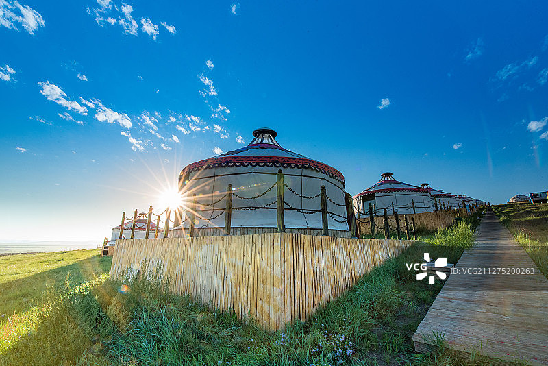 呼伦贝尔草原金帐汗部落一排排蒙古包和日出时的星芒图片素材