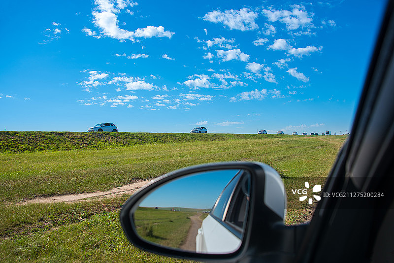 透过车窗，呼伦贝尔草原上的自驾游车队向天边开去图片素材