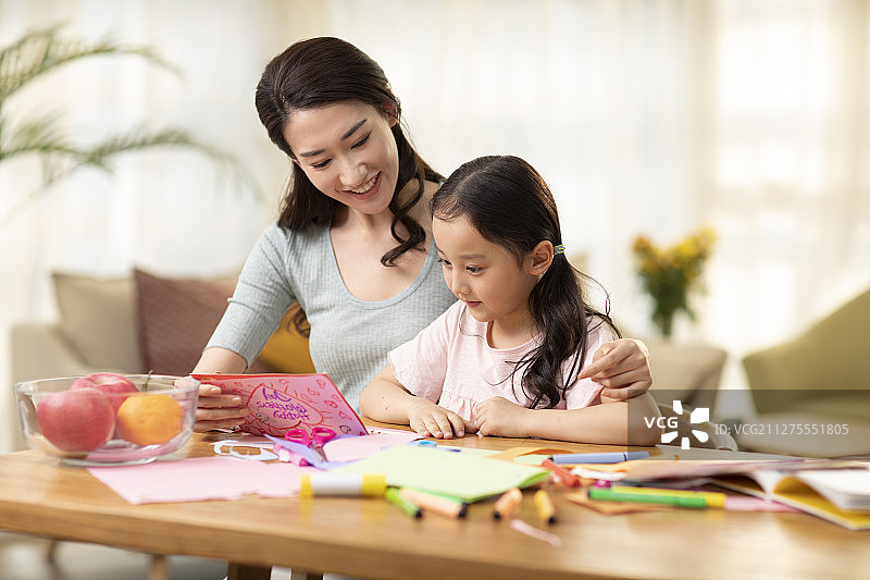 小女孩为母亲制作节日卡片图片素材