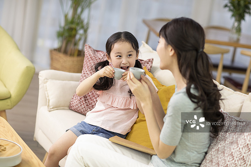 快乐的母女俩在客厅喝茶图片素材