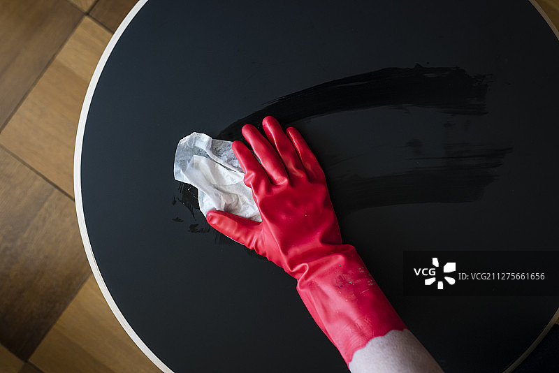 用消毒湿巾擦拭黑色咖啡桌表面图片素材