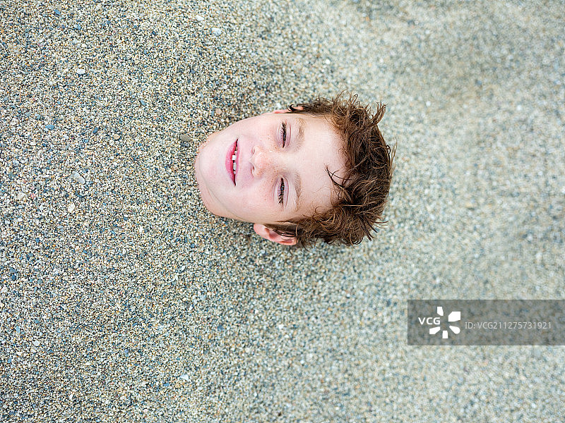 被沙子掩埋的小男孩图片素材