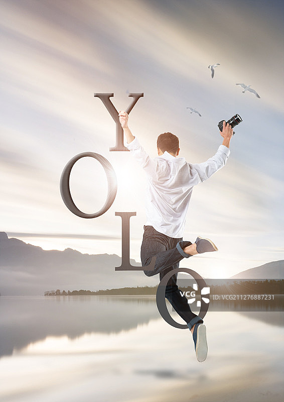 在湖边跳跃的年轻男摄影师图片素材