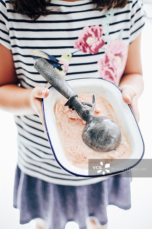 拿着桃子冰沙和冰淇淋勺的女孩图片素材