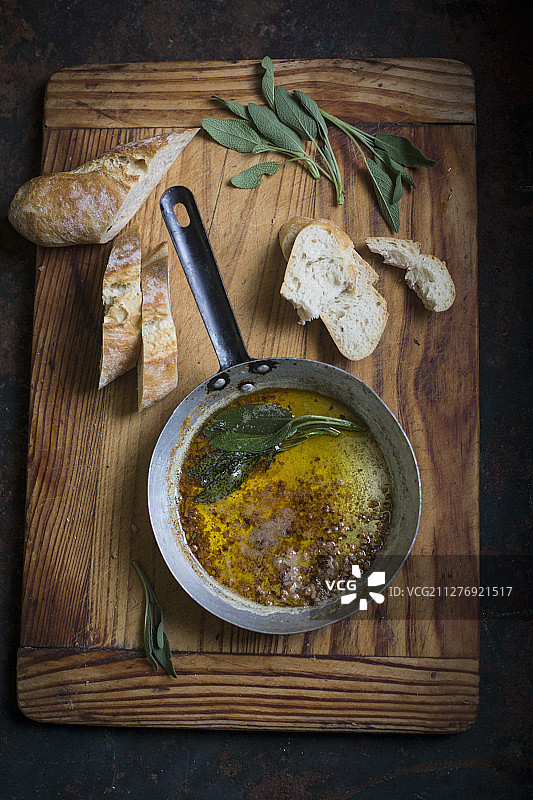 平底锅中的鼠尾草黄油和白面包片图片素材