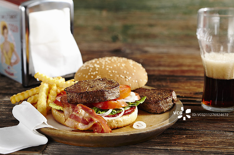 炸牛排汉堡配培根、番茄酱、薯条和可乐图片素材