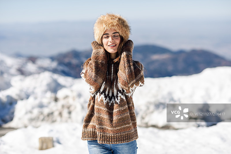 年轻女子在西班牙内华达山脉的雪山享受冬季图片素材