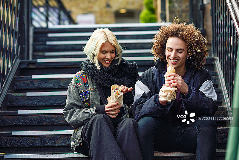 在伦敦卡姆登镇，情侣享用土耳其烤肉卷图片素材