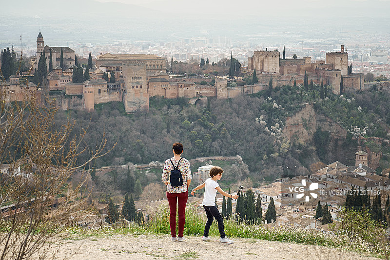 母亲和女儿在圣米格尔山上眺望格拉纳达阿尔罕布拉宫，单亲家庭旅游图片素材