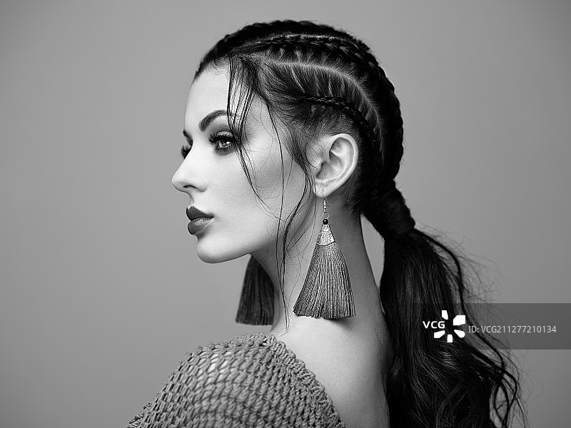 妆容精致的棕发女孩。发型美丽的模特。头发护理产品。编发女士。佩戴珠宝的模特。黑白照片图片素材