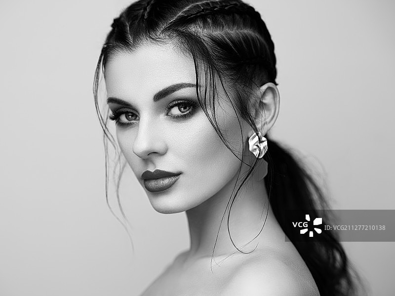 妆容精致的棕发女孩。发型美丽的模特。头发护理产品。编发女士。佩戴珠宝的模特。黑白照片图片素材