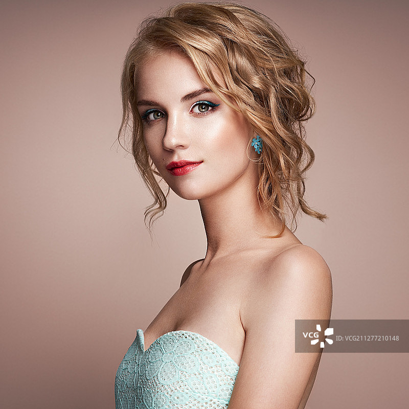 有着优雅卷曲闪亮发型的金发女孩，美丽的模特，护理和美发产品，完美的妆容图片素材