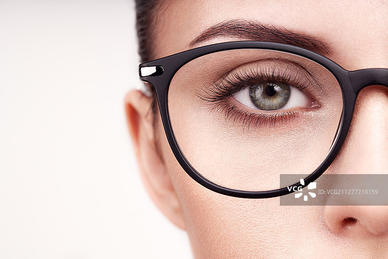 戴眼镜的长睫毛女性眼睛。眼镜模特。视力矫正。视力不好。眼镜框。化妆，化妆品，美容。特写，宏图片素材