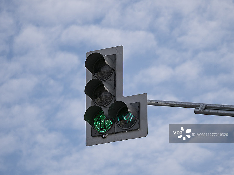 多节绿色交通信号灯与多云天空图片素材